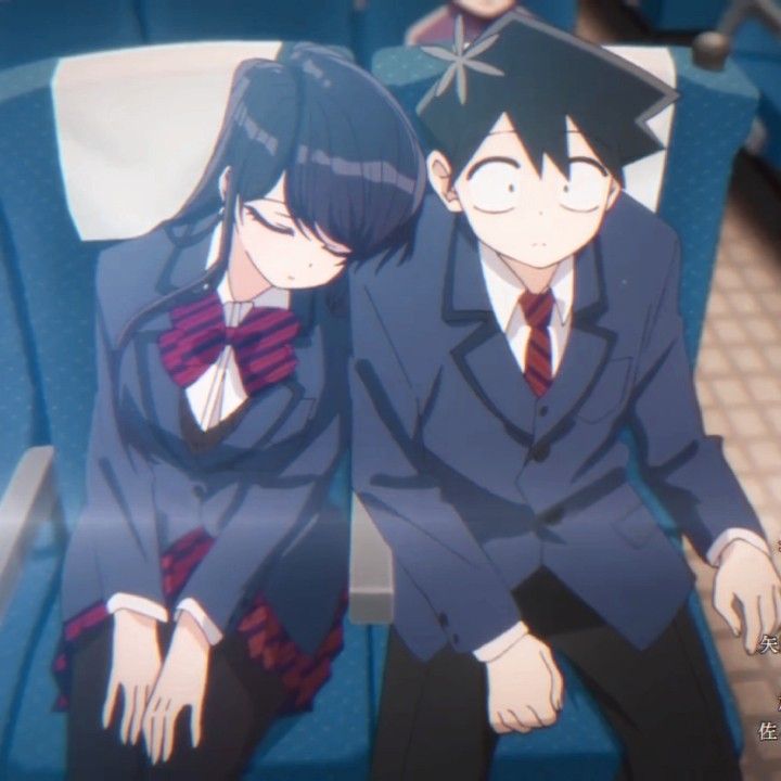 two anime characters sitting next to each other on a blue chair with their arms around one another