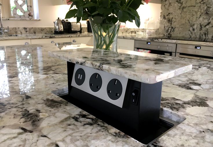 a vase filled with flowers sitting on top of a kitchen counter next to an oven