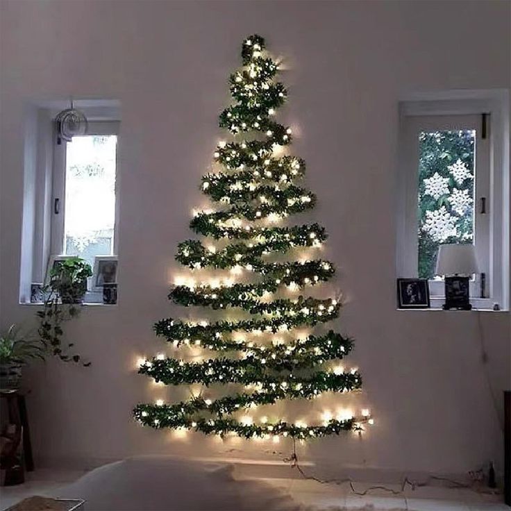 a christmas tree is lit up in the middle of a living room with lights on it