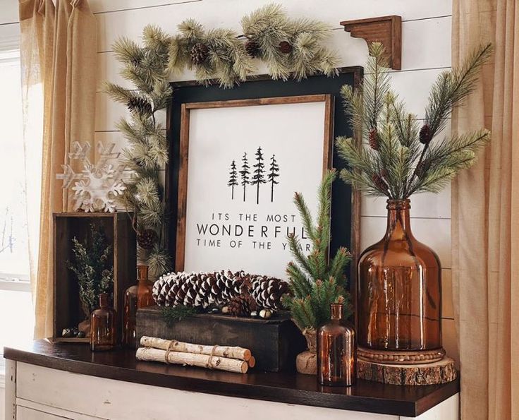 a mantle with pine cones, evergreens and other holiday decorations