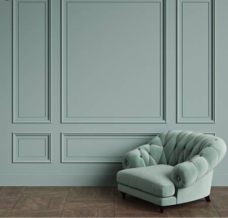 a green chair sitting in front of a wall with paneled panels on the walls