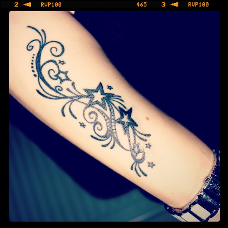 a woman's arm with stars and swirls on it