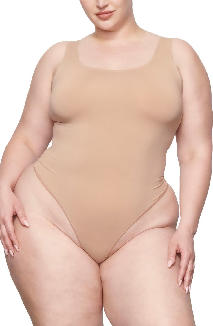 This scoop-neck bodysuit is the perfect everyday essential for light smoothing and support for your waist. It features a double scoop neck and a thong back that make it seamless under clothing. Pull-on style (no snap closure) Scoop neck Thong back Cotton-lined gusset 85% nylon, 15% elastane Hand wash, line dry Imported Stretch Leotard With Built-in Bra And Scoop Neck, Second-skin Scoop Neck Shapewear Swimwear, Second-skin Scoop Neck Leotard, Seamless Scoop Neck Shapewear For Summer, Solid Seamless Low Back Shapewear, Scoop Neck Second-skin Leotard, Seamless Shapewear Swimwear With Scoop Neck, Second-skin Smoothing Swimwear With Scoop Neck, Second-skin Smoothing Scoop Neck Swimwear