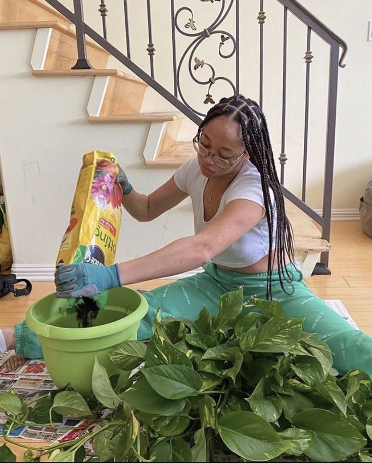 a woman sitting on the ground with some plants