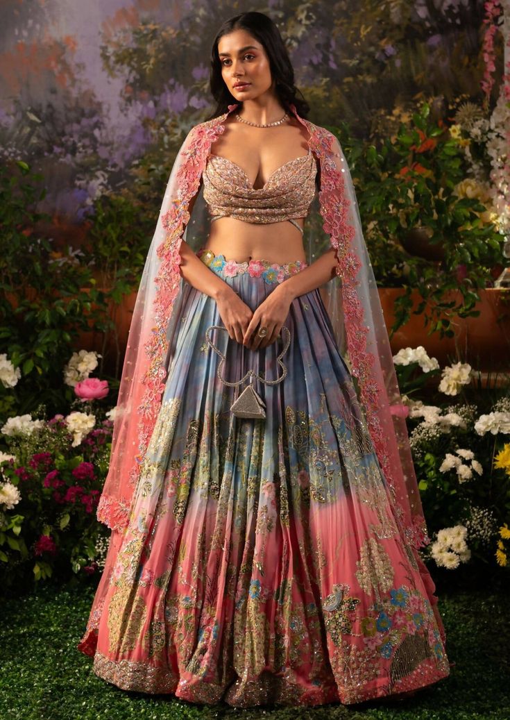 A captivating blend of hues and textures along with nalki crystals and lavish hand embroidery crafts this mesmerizing Iris lehenga set. The playful hues create that joyful vibe for the celebrations and as paired up with a glamorous cowl neck blouse the ensemble exudes a playful glam. With the complimentary net dupatta prepare to dazzle and make an unforgettable statement. The blouse features a cowl neckline embellished with sequins, beads, and nalki crystals. The blouse comes with attached rhine Lehenga Patterns, Engagement Mehndi, Sick Clothes, Cowl Neck Blouse, Pengantin India, Function Dresses, Lehenga Pattern, Indian Outfits Lehenga, Embroidery Crafts