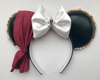 a minnie mouse ears headband with a white bow and black leather ear, on a white background