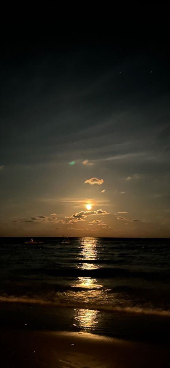 the sun is setting over the ocean with clouds in the sky and water on the beach