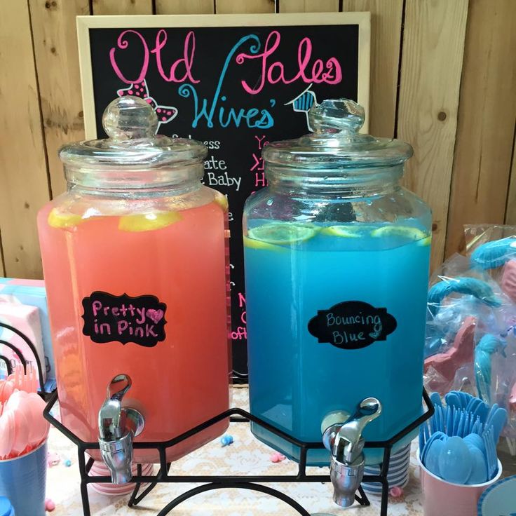 there are two large jars with blue and pink liquid in them sitting on a table