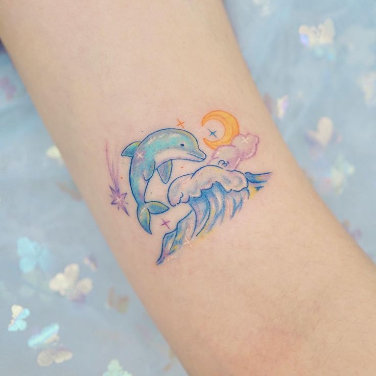 a small dolphin tattoo on the arm