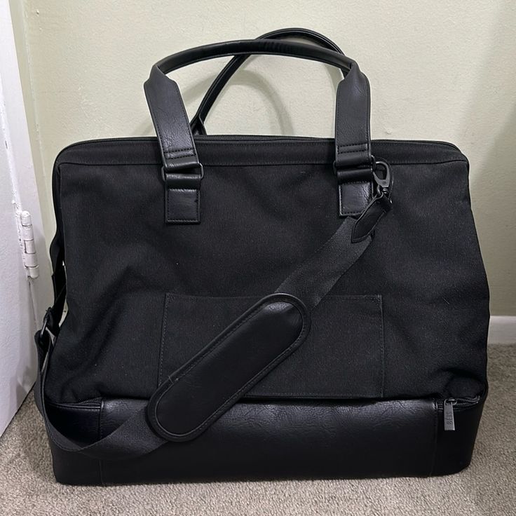 a black bag sitting on the floor next to a door