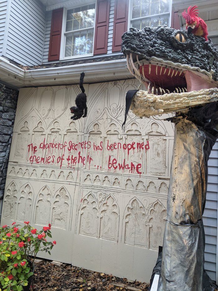 there is a fake alligator head in front of a house with graffiti on the wall