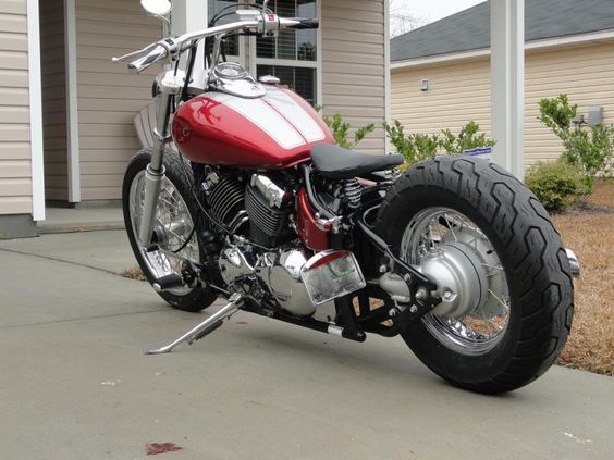 a red motorcycle parked in front of a house