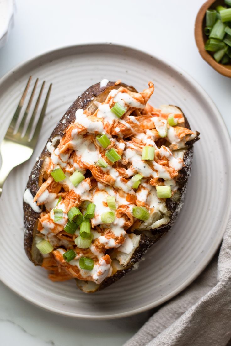 garnished buffalo chicken baked potato on a plate Greek Yogurt Ranch Dressing, Shredded Buffalo Chicken, Chicken Potato Bake, Spicy Buffalo Chicken, Paleo Slow Cooker, Baked Buffalo Chicken, Stuffed Sweet Potatoes, Chicken Stuffed, Healthy Buffalo Chicken