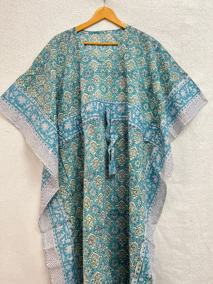 This Beautiful Hand Block Print Caftan or can be called as Tunic is made with super fine quality cotton and designs have been crafted by Hand Printed Usage - Tunic, Gown, Maxi, Bikini Cover up, Beach Wear, Caftan, Party Wear Top. Fabric - Organic Cotton Color - Light Blue Pattern - Floral Print Size - One Plus Size, can fit Upto 4XL Bust Size - Free Size ( Drawstring ) Long Caftan Length - 50" Inches (Approx ) * It has Adjustable Drawstring Waist. * V Shape Neck Which is 7" Inches Deep. * Very c Traditional Summer Block Print Kimono, Traditional Summer Kimono With Block Print, Bohemian Beach Kimono For Festive Season, Bohemian Green Kaftan With Kimono Sleeves, Festive Bohemian Beach Kimono, Festive Beach Kaftan With Kimono Sleeves, Bohemian Style Long Green Kurta, Festive Bohemian Kimono For Vacation, Green Long Bohemian Kurta