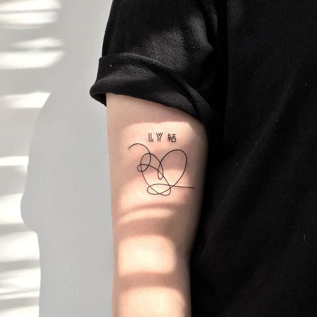 a woman's arm with a tattoo on it that says ly is in the shape of a heart