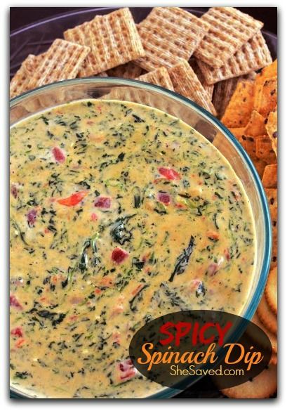 spinach dip in a glass bowl surrounded by crackers