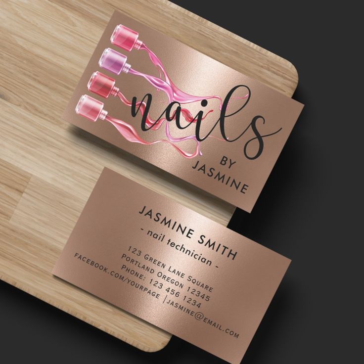 two business cards with the name nails by jasmine on them, sitting on top of a wooden cutting board