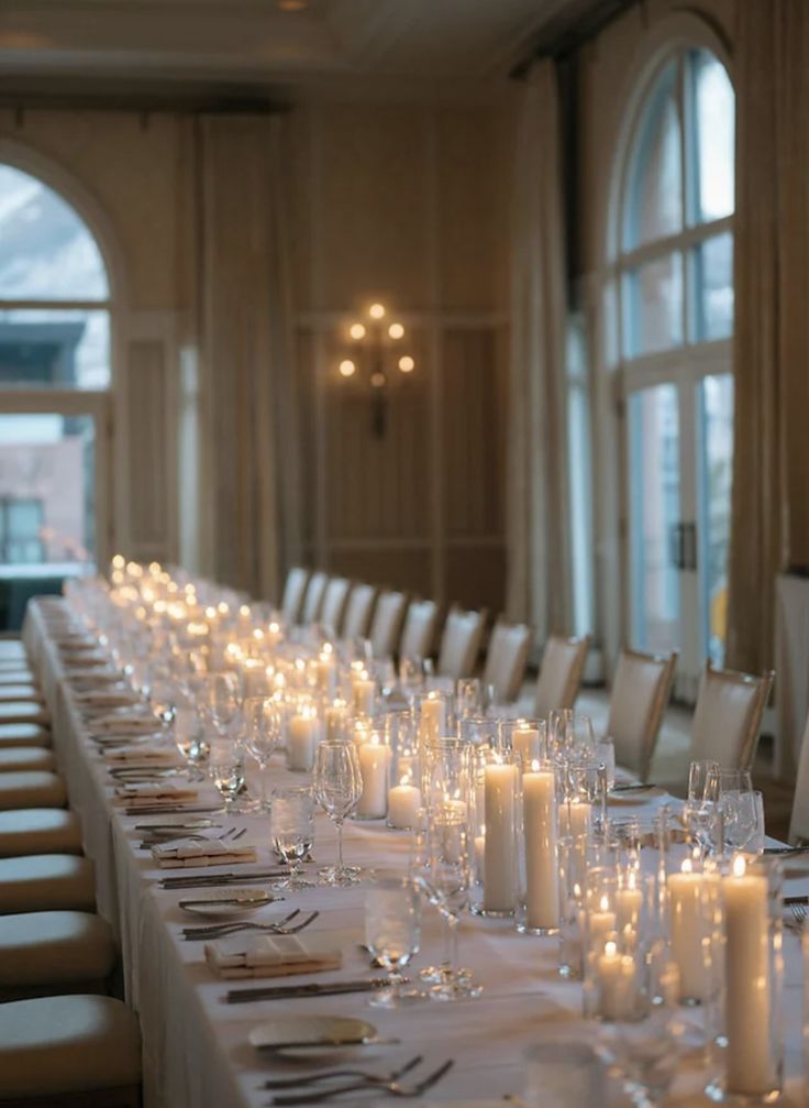 a long table is set with candles and place settings