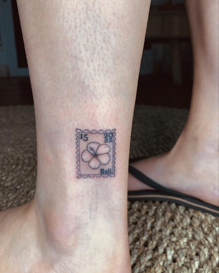 a small tattoo on the ankle of a woman's foot, depicting two flowers