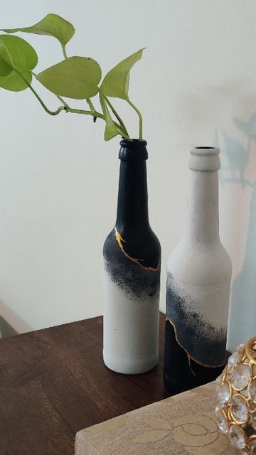 two vases with plants in them sitting on a table