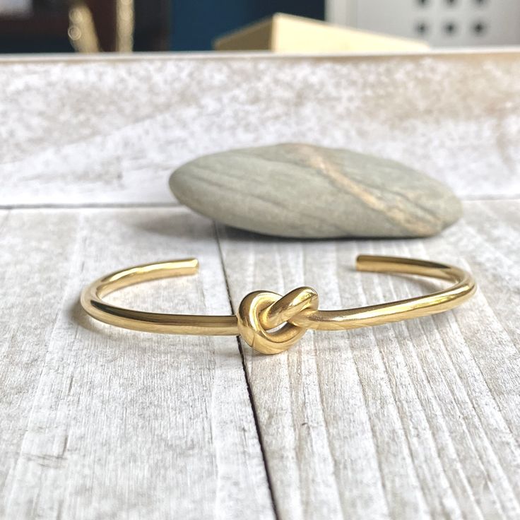 ✦ 14K Gold Ion Plating over Stainless Steel✦ Size: 2.25"inner diameter ✦ Inner Circumference is 6.5" but these are super adjustable and can fit larger or smaller wrists by simply squeezing them together or pulling the two sides apart. Super sweet gold knot bangle bracelet. Love knots represent LOVE, unity, and friendship. Would make perfect bridesmaid bracelets or gifts for someone you love. These will arrive ready for gifting in a cute boho gift box. KEY FEATURES*-These are 14k gold ion plated Four Knot Bracelet, Screw Knot Bracelet, Concentric Knot Bracelet, Bracelet Tie, Bridesmaid Bracelets, Friendship Knot, Love Knots, Raw Stone Earring, Knot Bangle