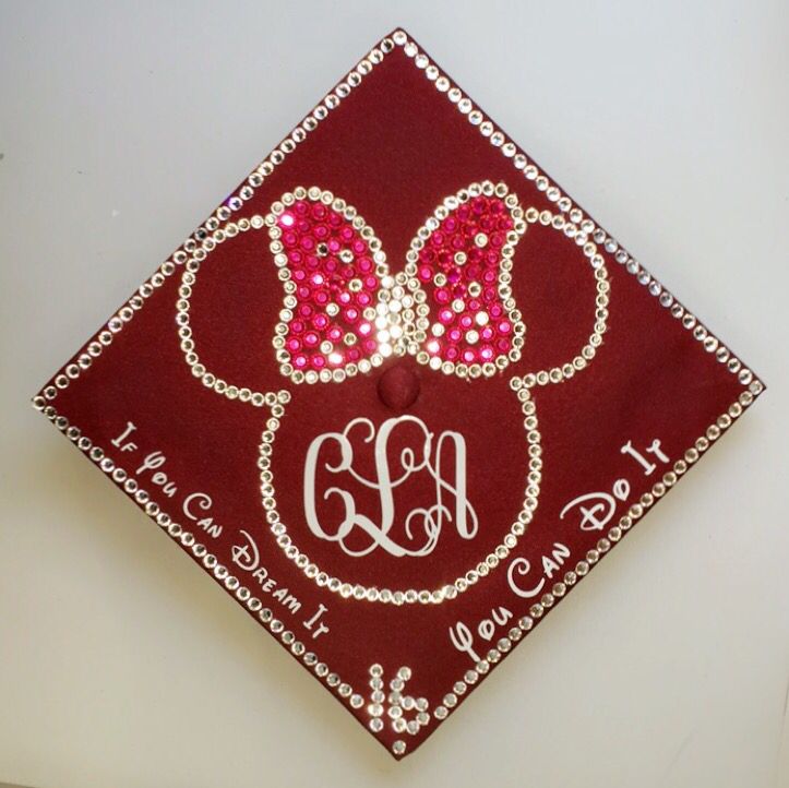 a red and white graduation cap with minnie mouse ears on it's side, decorated with swaroons