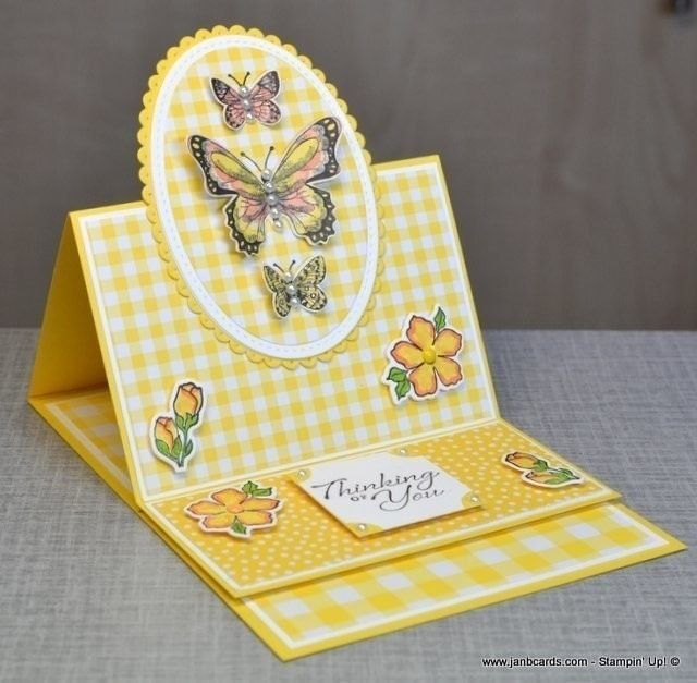 a yellow and white greeting card with butterflies on it, sitting on a table top