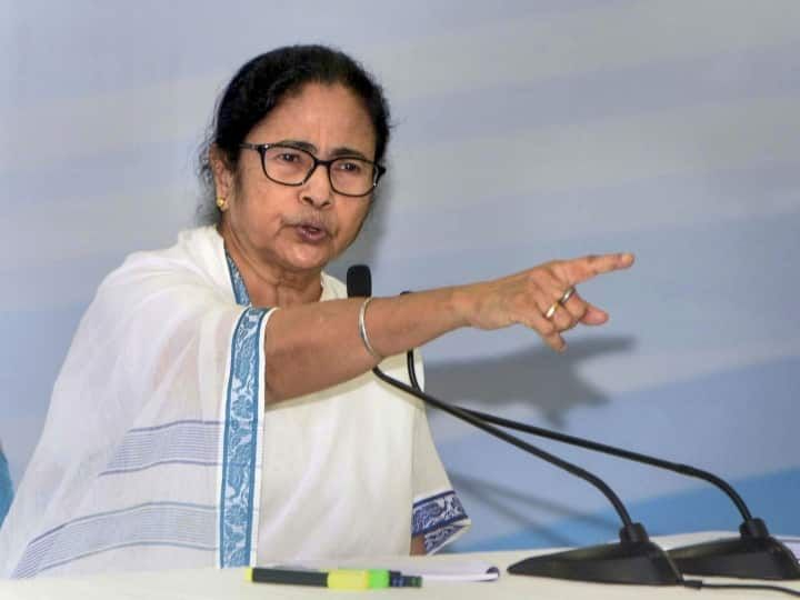 the woman is giving a speech in front of a microphone with her hand out and pointing