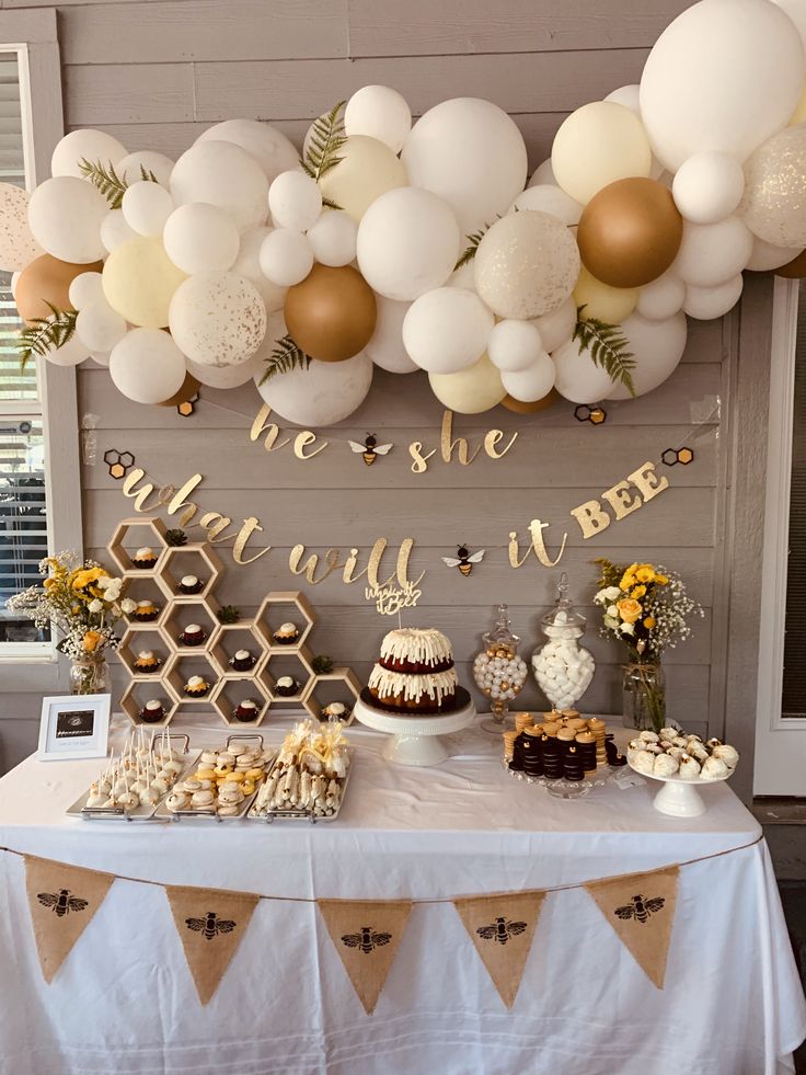 a table with desserts and balloons on it