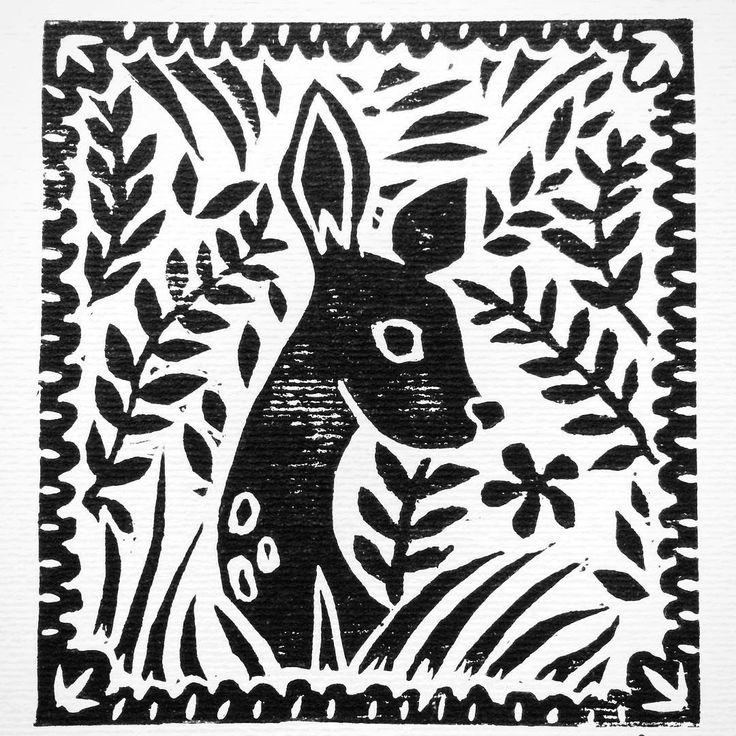 a black and white drawing of a deer surrounded by leaves on a sheet of paper