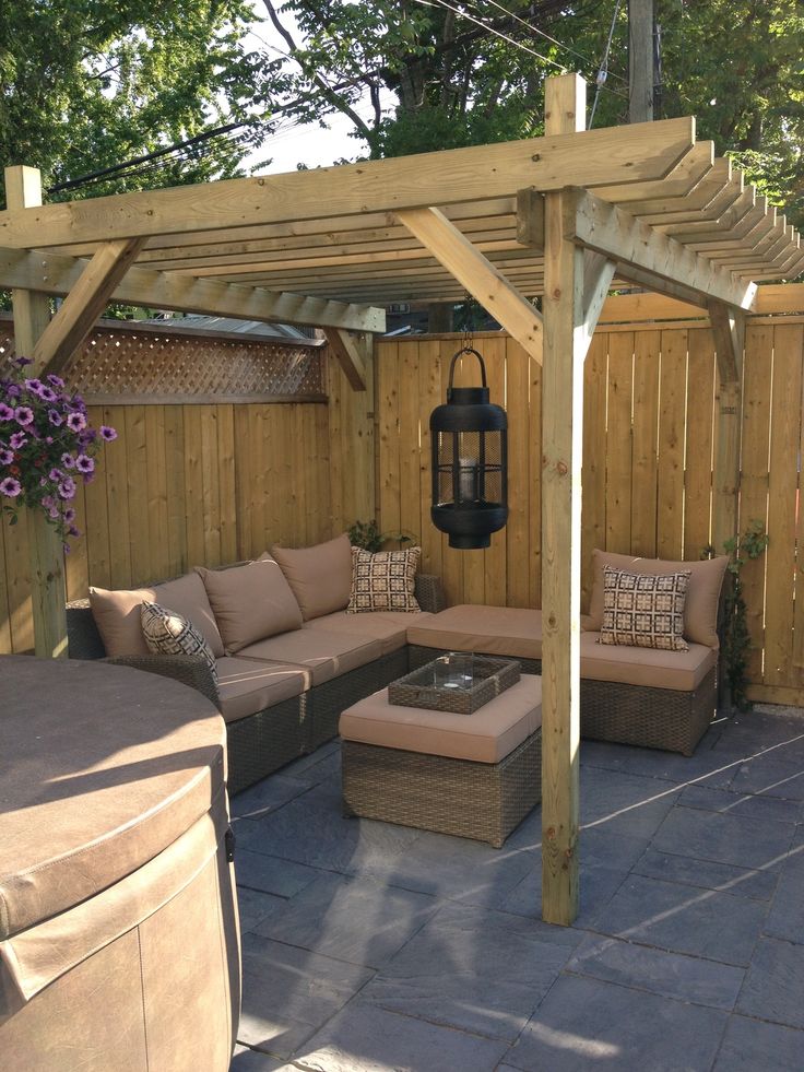 an outdoor living area with couches, table and gazebo in the back yard