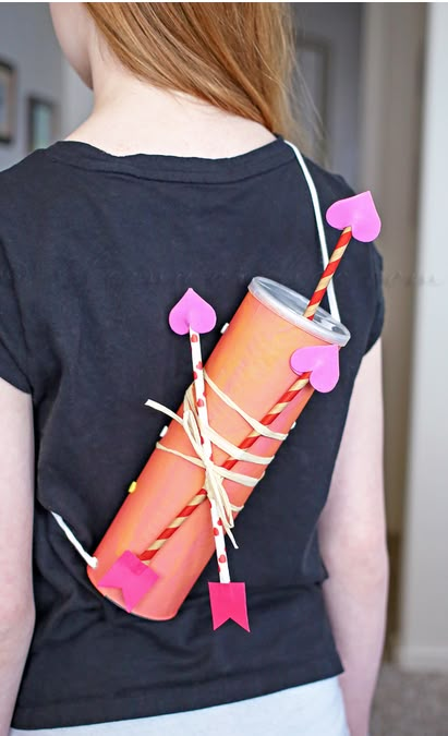 a woman wearing a t - shirt and holding a can with string attached to it