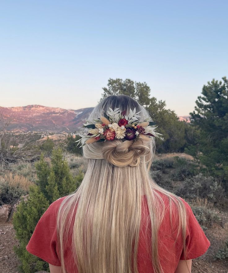 a woman with long blonde hair wearing a flower crown on her head in the desert