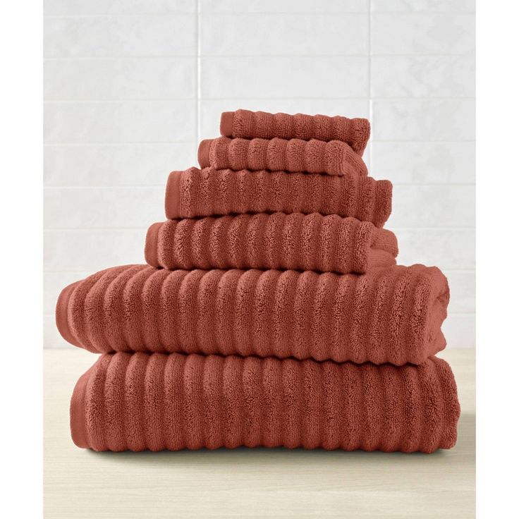 towels stacked on top of each other in front of a white wall