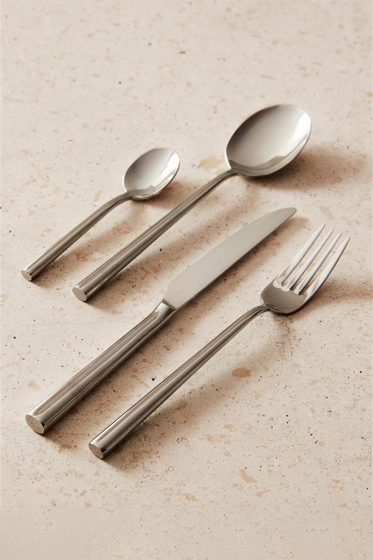 four spoons, two forks and one knife on a table