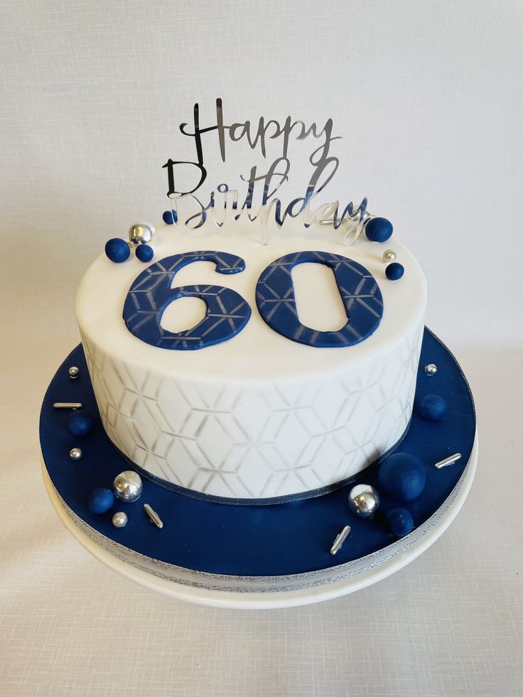 a white and blue birthday cake with the number sixty on it's side, sitting on a plate