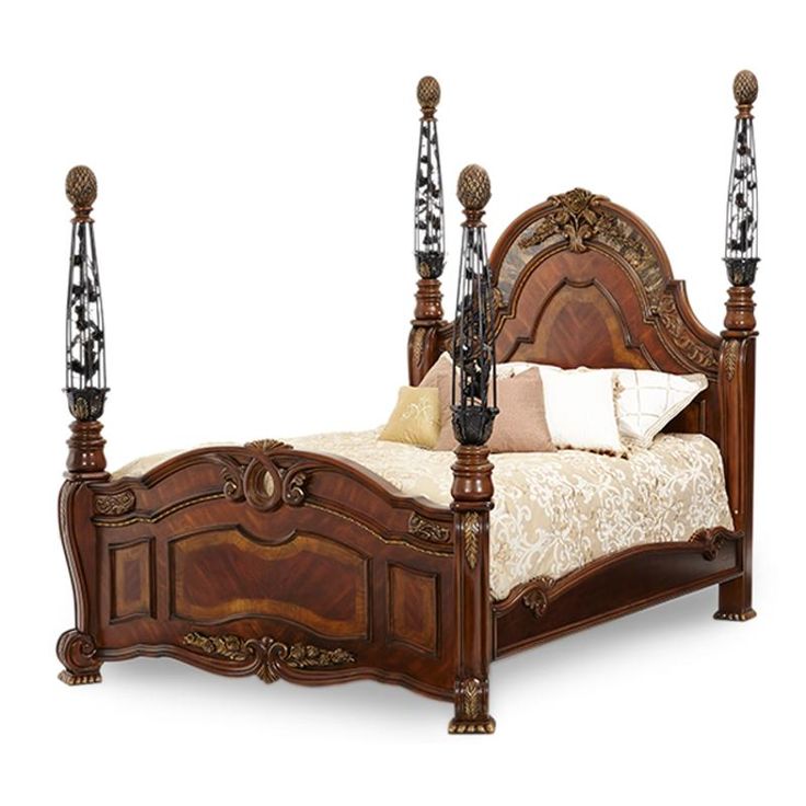 an ornate wooden bed with four posts and pillows on the headboard, along with two night stands