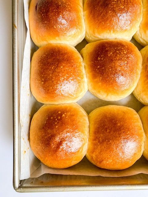 six rolls in a baking pan on a table top, ready to go into the oven