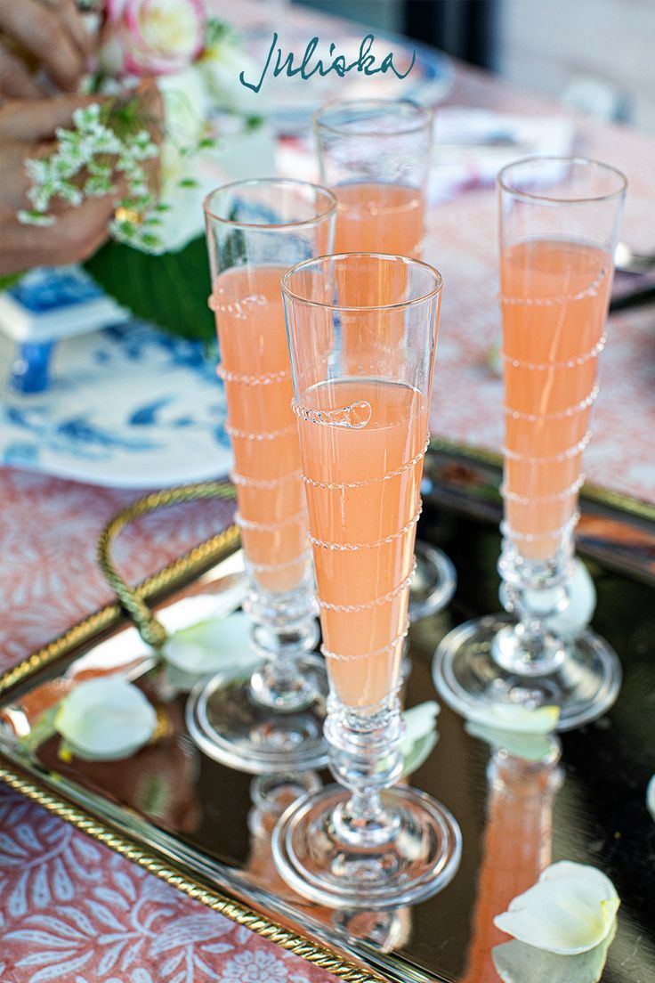 four champagne flutes are sitting on a tray