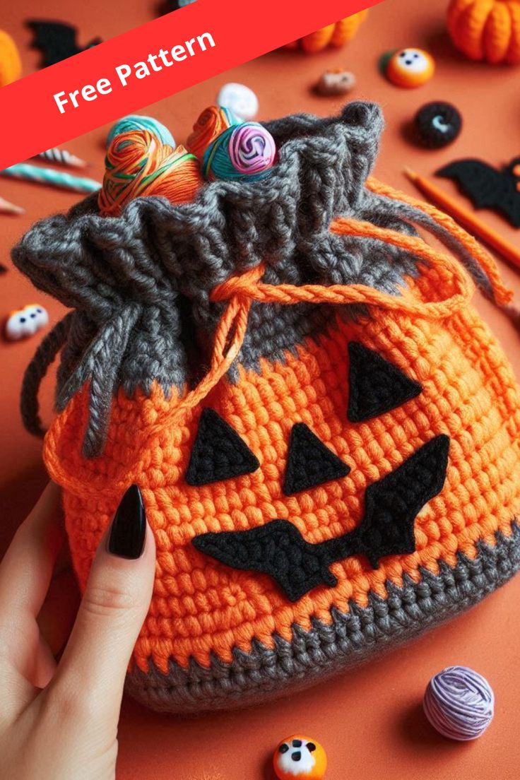 a crocheted pumpkin bag with yarn and buttons on it, surrounded by halloween decorations