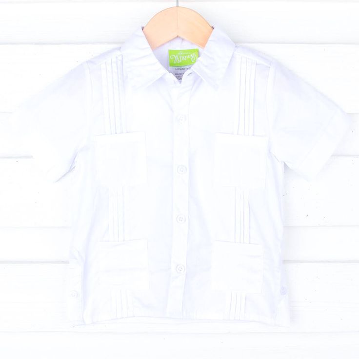 Don't forget to pack this Solid White Guayabera for your next resort vacation this summer or Cinco de Mayo celebration! It features four front pockets and pleated details. Personalize this short sleeve Guayabera shirt for your toddler boy or big kid by adding a monogram. *Please note the pocket will be sewn shut if a monogram is added. Solid Beach Camp Shirt With Pockets, Solid Color Camp Shirt With Pockets For Beach, Solid Summer Camp Shirt With Pockets, White Short Sleeve Beach Shirt With Pockets, White Short Sleeve Shirt With Pockets For Beach, Fitted Collared Short Sleeve Shirt For Beach, Fitted Collared Short Sleeve Beach Shirt, White Summer Camp Shirt With Pockets, Summer White Camp Shirt With Pockets