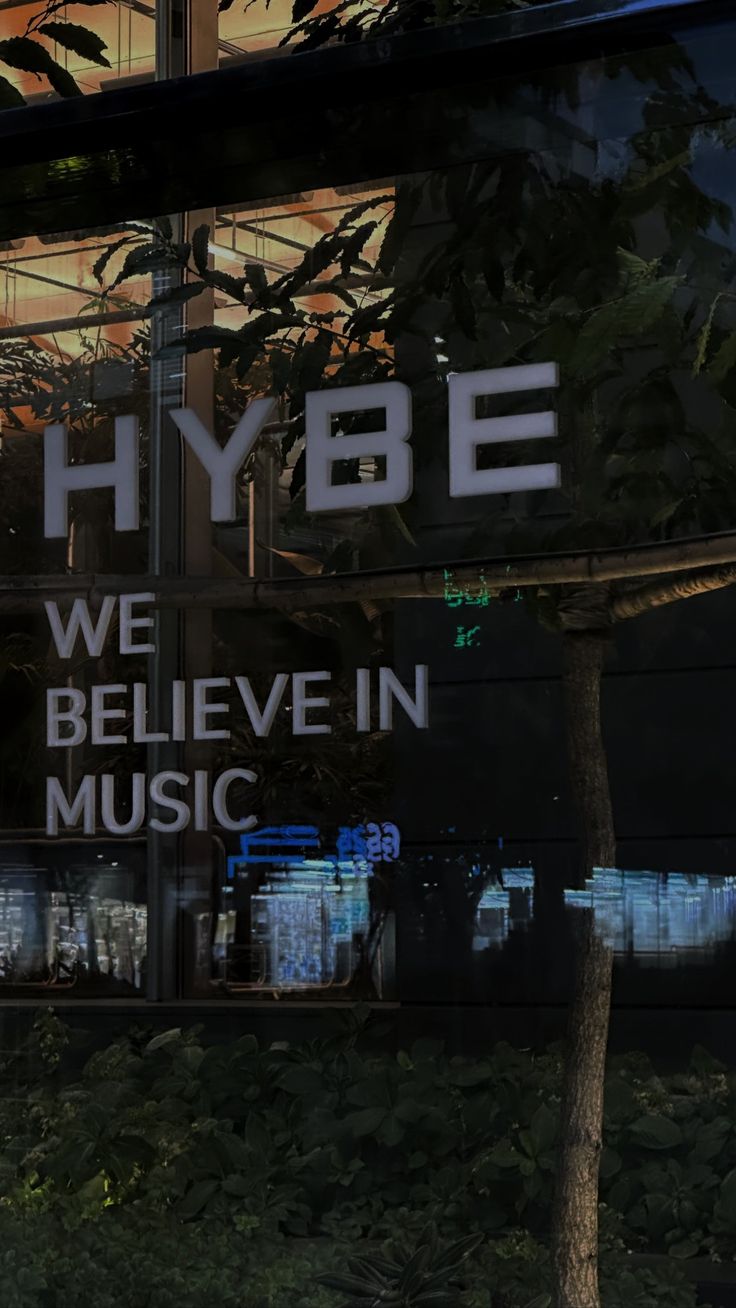 there is a sign that says hybe we believe in music on the side of a building