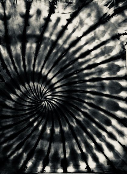 a black and white photo of a tie - dyed wall hanging on a door frame