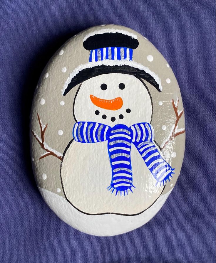 a painted rock with a snowman on it