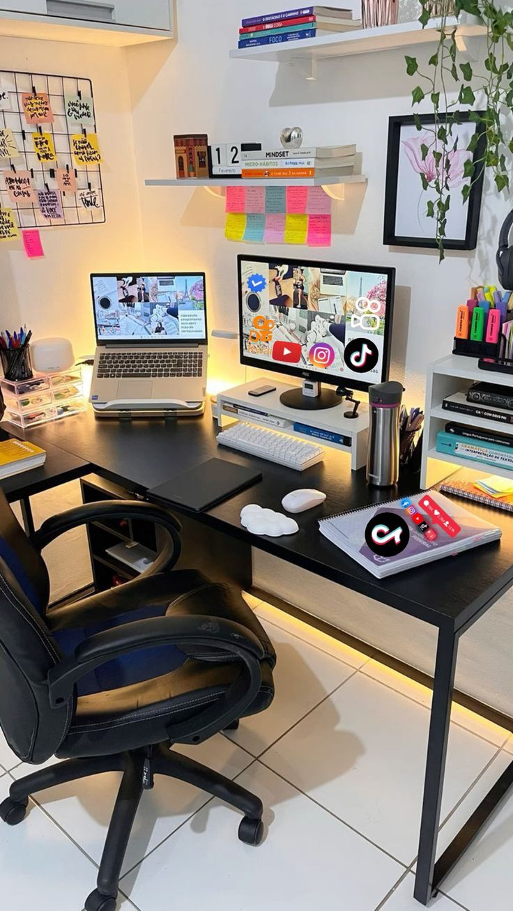 a desk with two computer monitors and a laptop on it in front of a plant