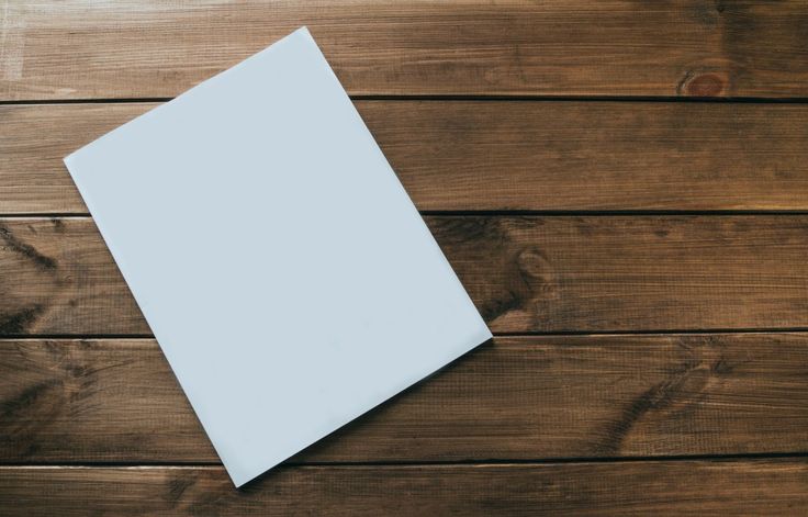 an overhead view of a white square object on a wooden surface with space for text