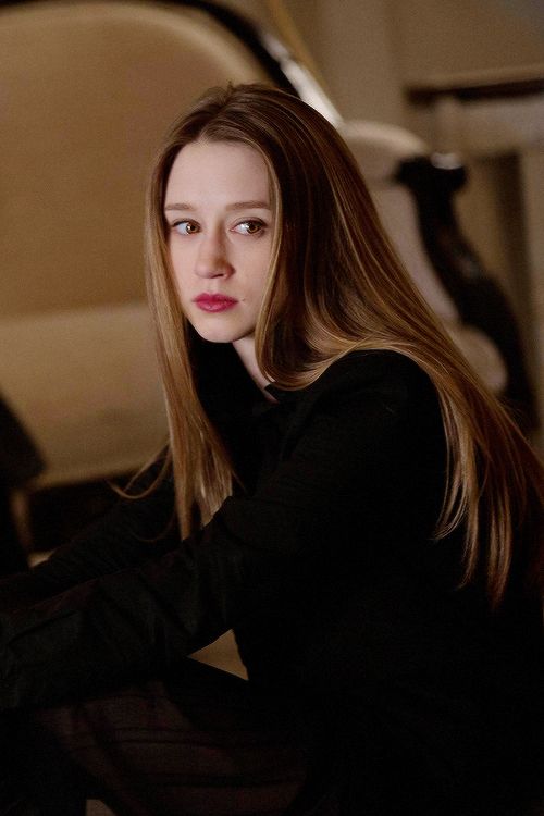 a woman with long hair sitting on a couch