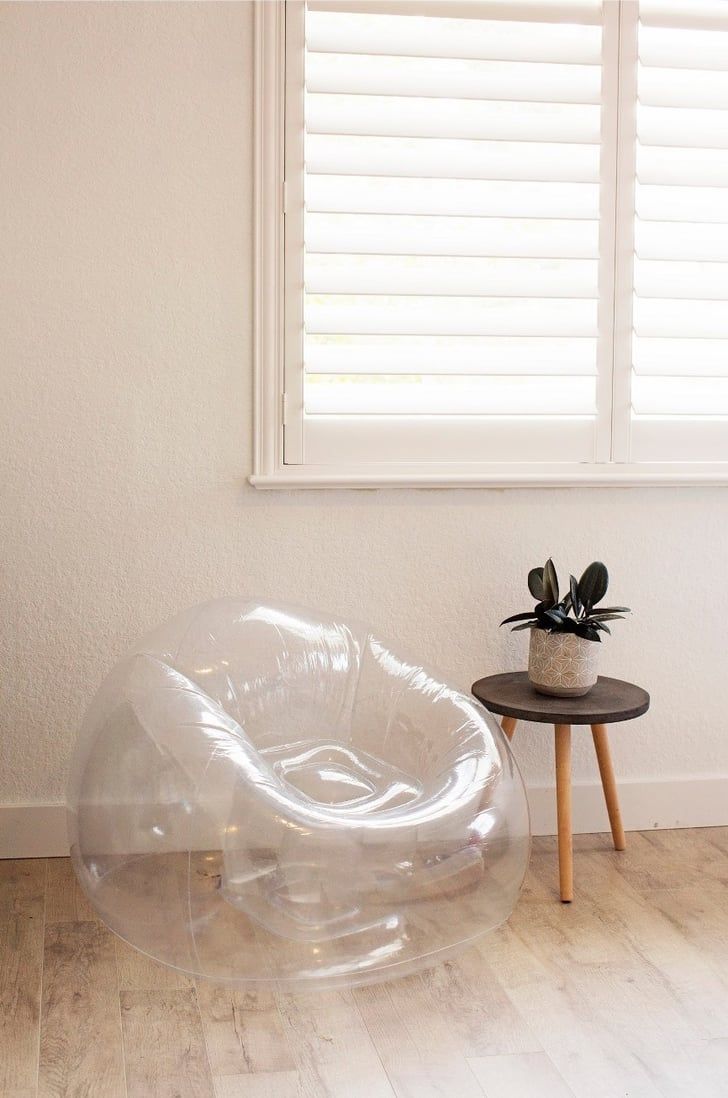 an inflatable chair sitting on top of a wooden floor next to a window