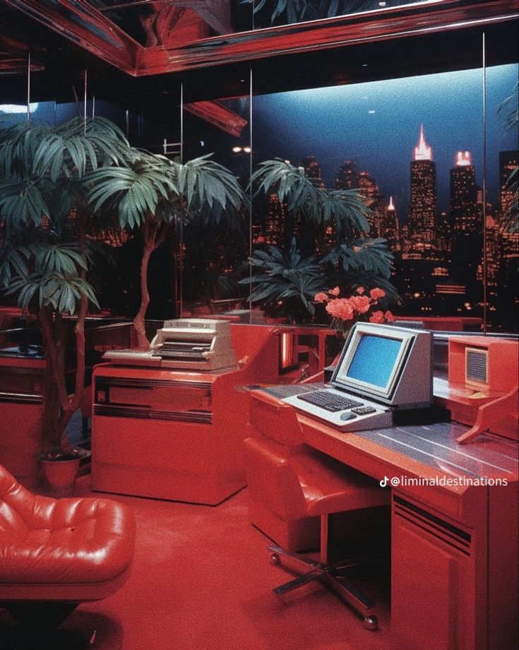 a desk with a laptop on top of it in a room filled with palm trees