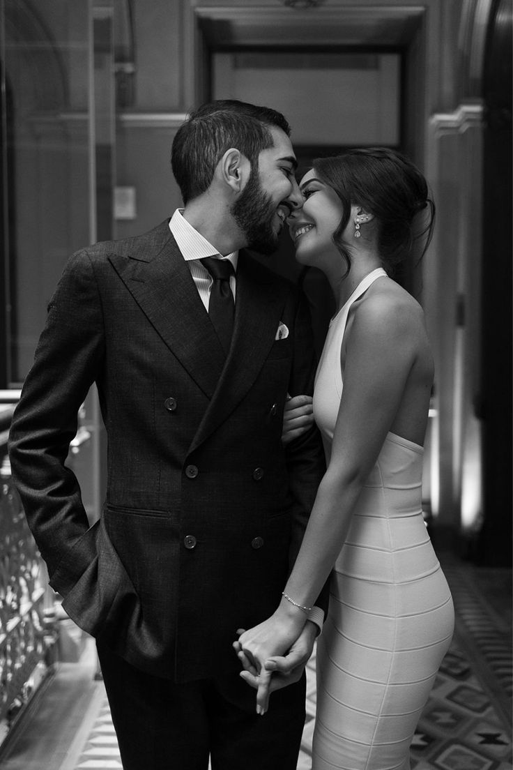 a man in a suit and tie standing next to a woman